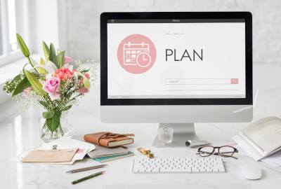 computer on a desk with a Plan worksheet showing on screen